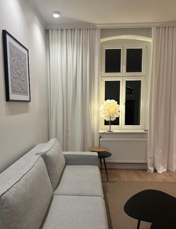 a living room with a couch and a window at Carola7 in Szczawno-Zdrój