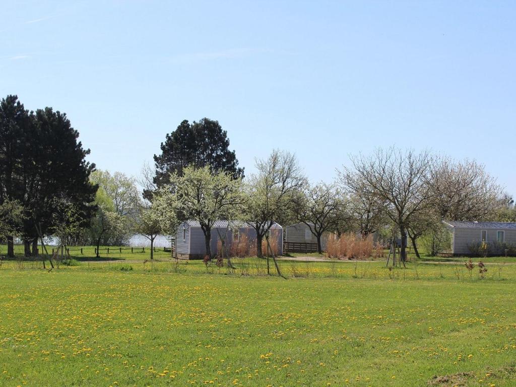 ein Grüngrasfeld mit Bäumen und Gebäuden in der Unterkunft Gîte Bures, 3 pièces, 4 personnes - FR-1-584-304 in Bures