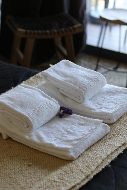 four white towels sitting on top of a table at Zambujal Suites in Sesimbra