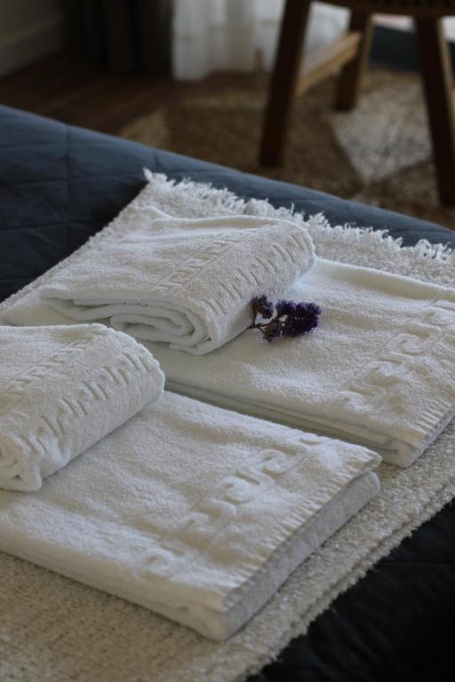 three white towels sitting on top of a table at Zambujal Suites in Sesimbra