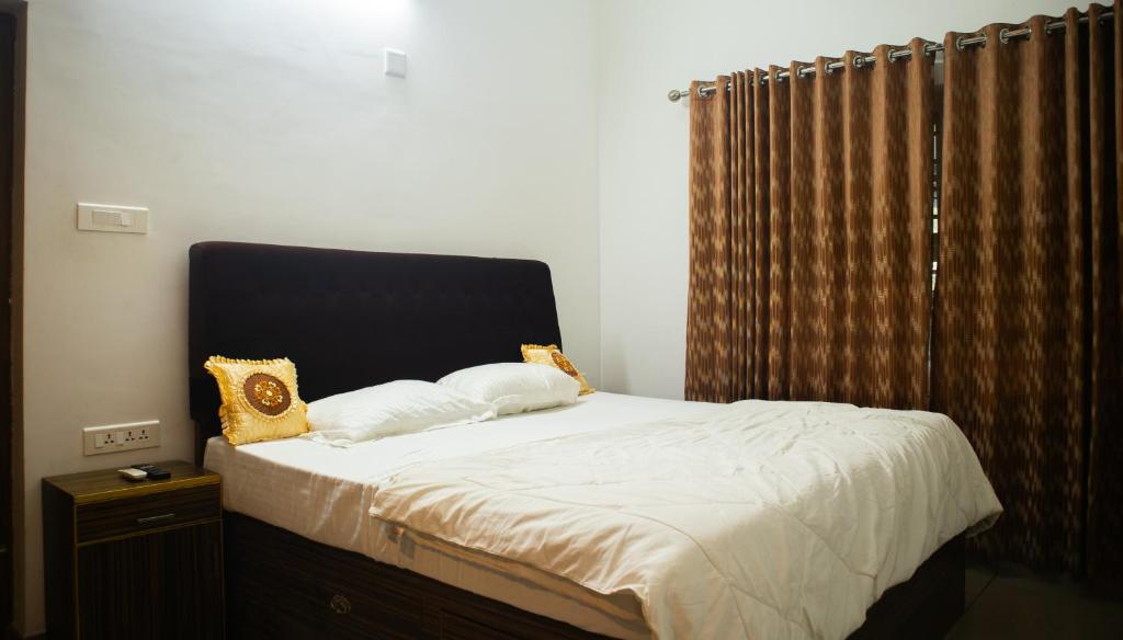 a bed with two pillows on it in a bedroom at Urban Oasis Homestay: AC Bedrooms in Trichūr