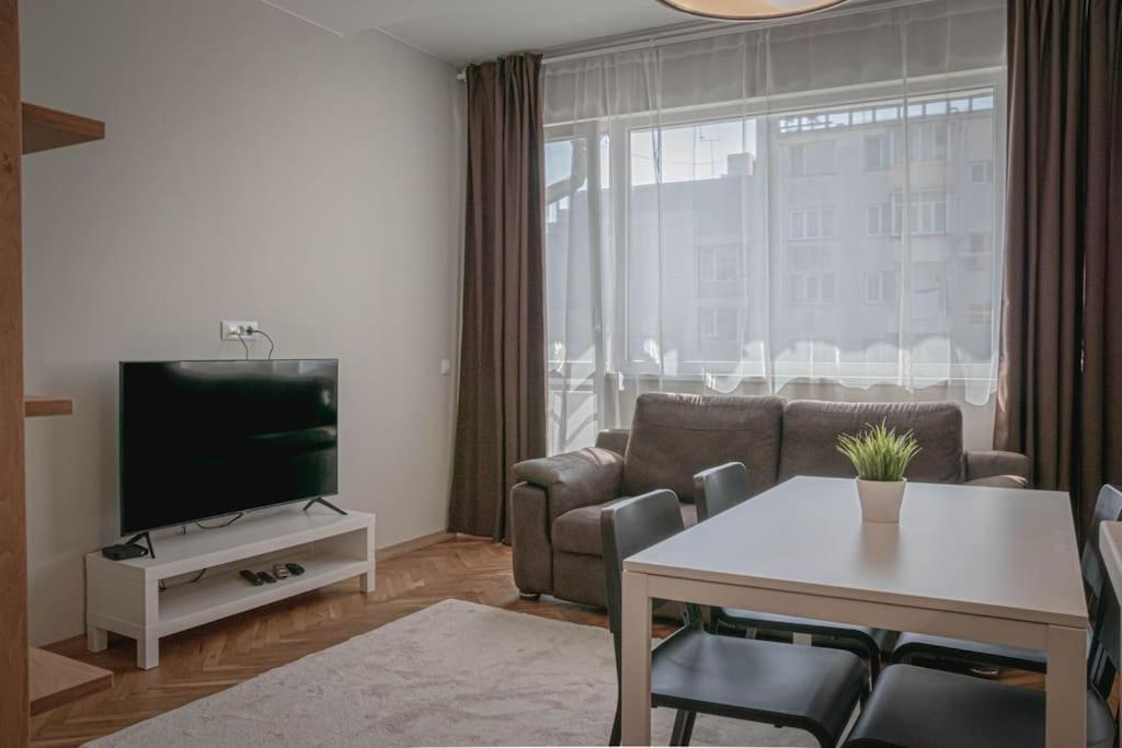 a living room with a couch and a table and a tv at Central Apartment in Varna in Varna City