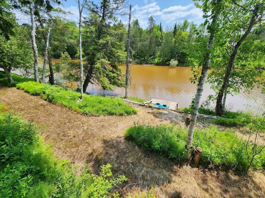 Riverfront~On ATV Trials~Near Mackinac Island في Hessel: اطلاله على تجمع مياه بالاشجار