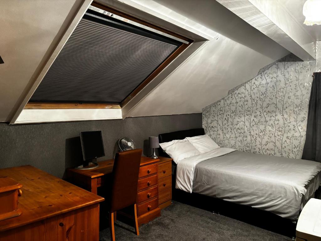 una camera con letto, scrivania e finestra di KAYUMBA Properties LTD a Leeds