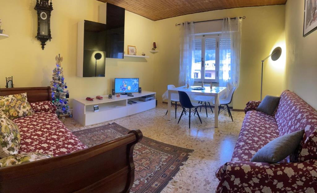 een woonkamer met een bank en een tafel met een kerstboom bij AL CAMPANILE centro storico ampio luminoso e panoramico appartamento trilocale in Carsoli