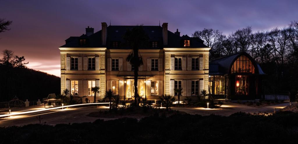 Une grande maison blanche éclairée la nuit dans l'établissement Domaine de Locguénolé & Spa - Relais & Chateaux, à Kervignac