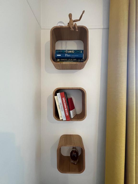 a bathroom with two wooden shelves with books at Vanves : 2 pièces lumineux aux portes de Paris in Vanves