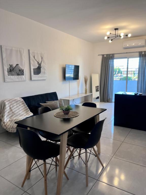 a dining room and living room with a table and chairs at Luminoso departamento con cochera in San Juan