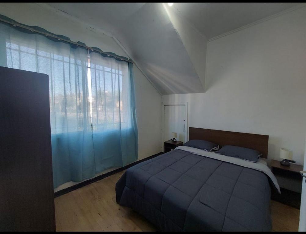 a bedroom with a bed and a large window at Casa Grande En Recreo in Viña del Mar