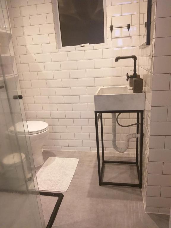 a bathroom with a sink and a toilet at Flat na Rua XV 2107 in Curitiba