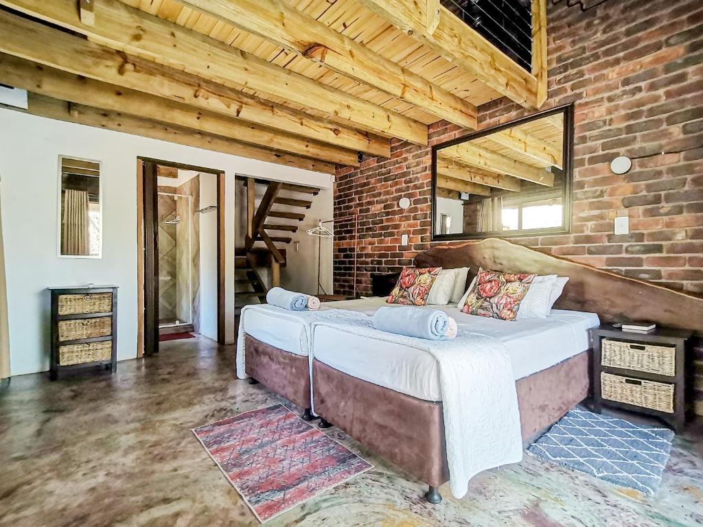a bedroom with two beds in a brick wall at Athule Marloth in Marloth Park