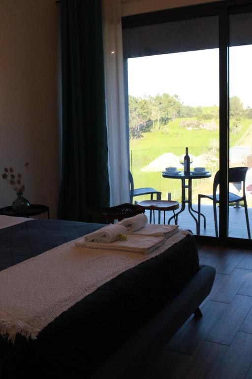a bedroom with a bed with a view of a golf course at Zambujal Suites in Sesimbra