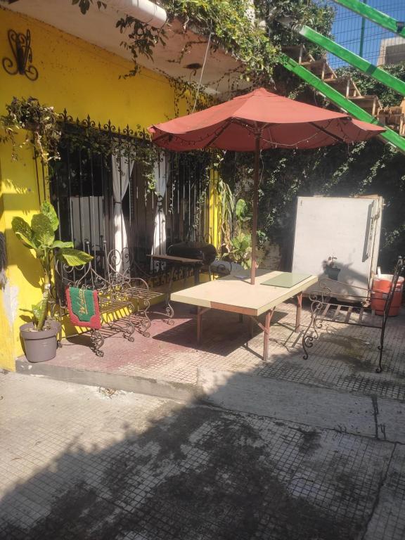 stół piknikowy i parasol przed budynkiem w obiekcie Casa céntrica antigua completa w mieście Orizaba