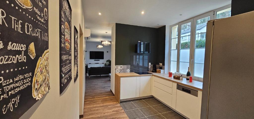 a kitchen with a wall with a sign on it at Le Clos Maldier - Gîte de la Belle vue in Laon