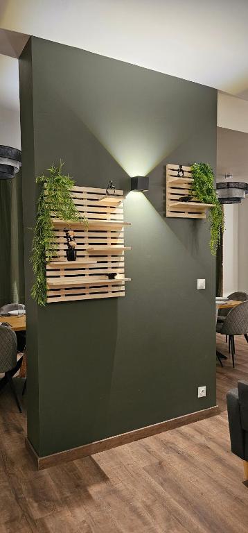 a room with a green wall with some plants at Le Clos Maldier - Gîte de la Belle vue in Laon