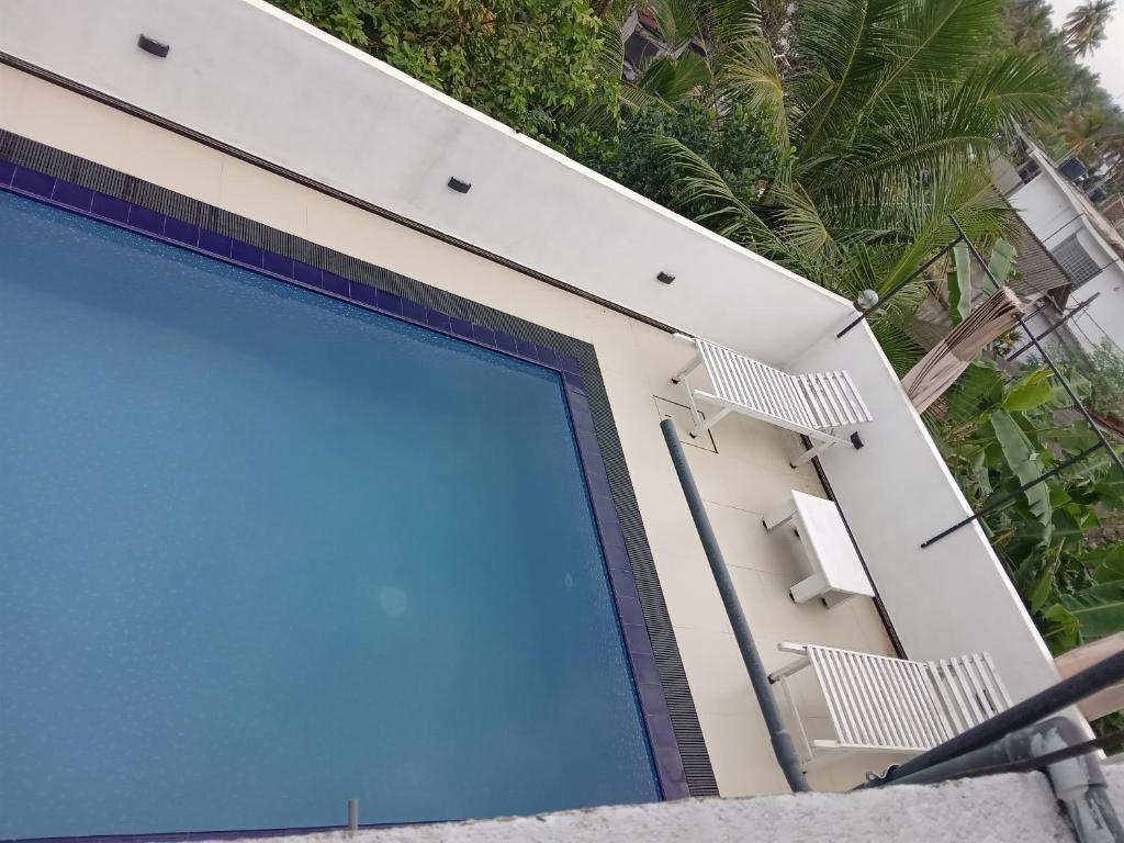 a swimming pool with two chairs on a building at VILLA AAA WELIGAMA in Weligama