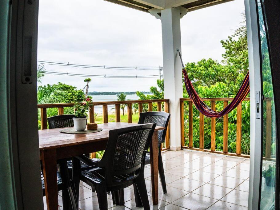 a table and chairs on a balcony with a view of the ocean at Beachfront Apartment near Bocas Town in Istmito