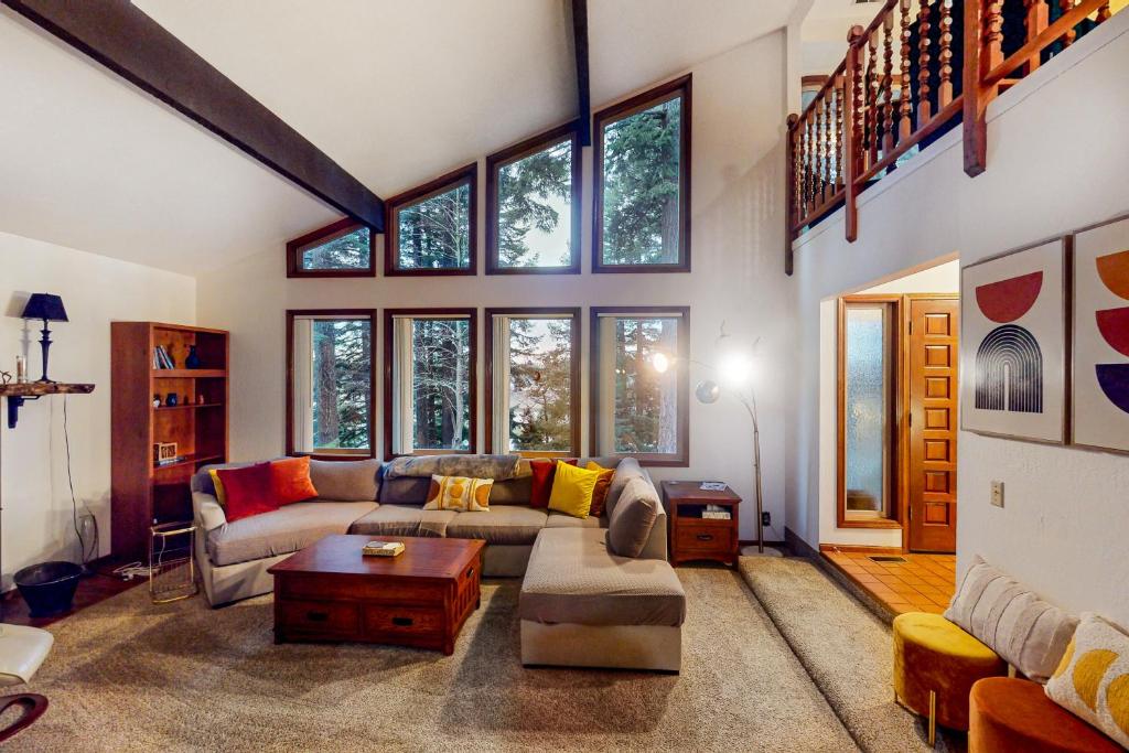 a living room with a couch and some windows at The Pony Creek Forest Retreat in North Bend