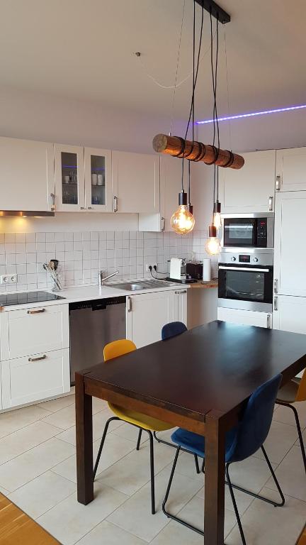 een keuken met een houten tafel en stoelen. bij Penthouse Nähe Frankfurt am Main in Hanau am Main