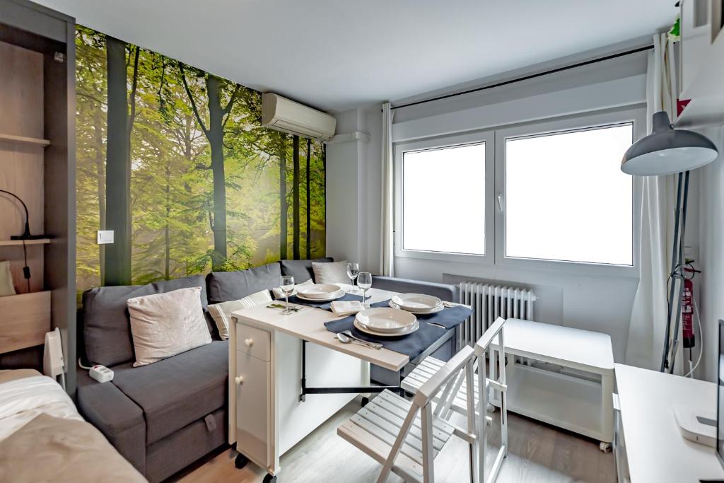 una pequeña sala de estar con mesa y sofá en Apartamentos Hortaleza, en Madrid