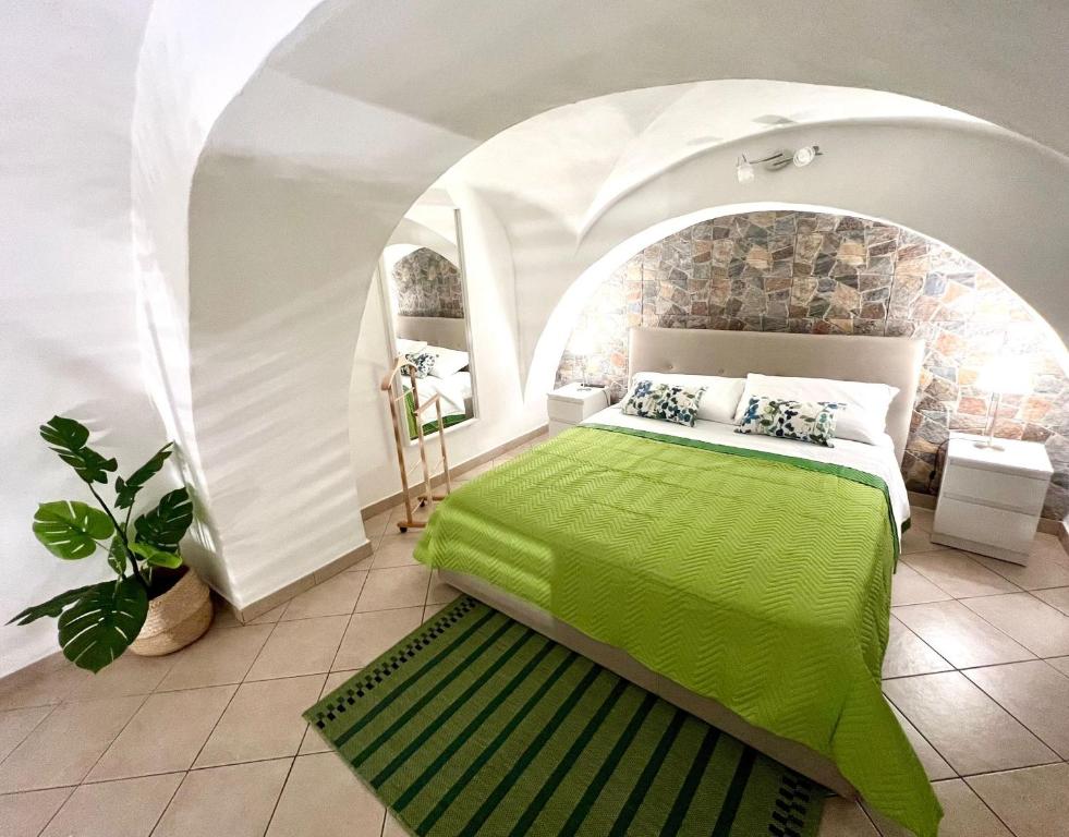 a bedroom with a green bed in an archway at Ursino holiday apartment in Catania