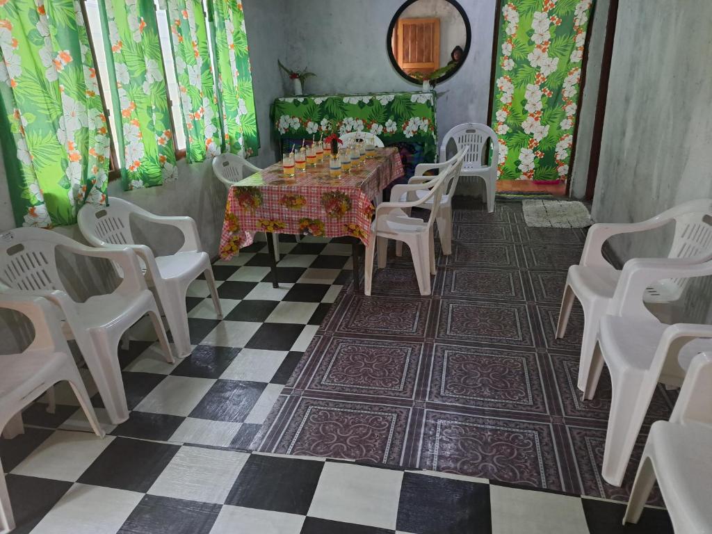 a dining room with a table and chairs on a checkered floor at Appartement de Charles in Loméméti