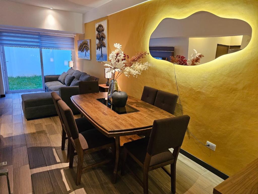 a dining room with a table and a yellow wall at Torre Pamplona 102-Nuevo y Céntrico-Apartamento in Guatemala