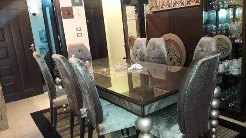 a glass table and chairs in front of a mirror at شقه مفروش في التجمع الخامس in Cairo