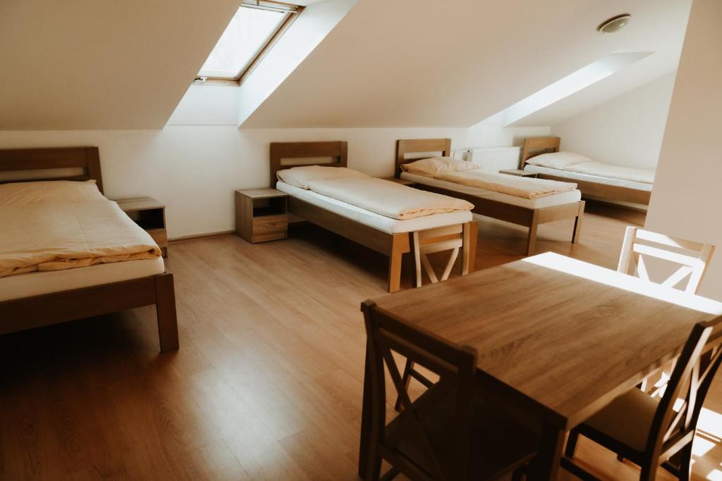 een kamer met drie bedden en een tafel erin bij Penzión Enbra 