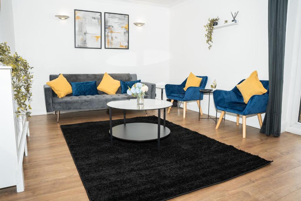 sala de estar con sofá, mesa y sillas en Stylish 3 bed house with free parking en Belle Isle