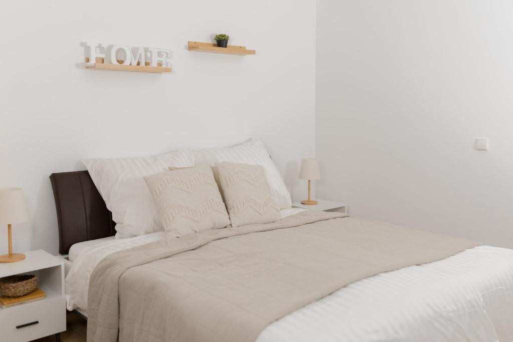 a white bedroom with a large bed with white sheets at Ferienwohnung Rheinauen in Germersheim