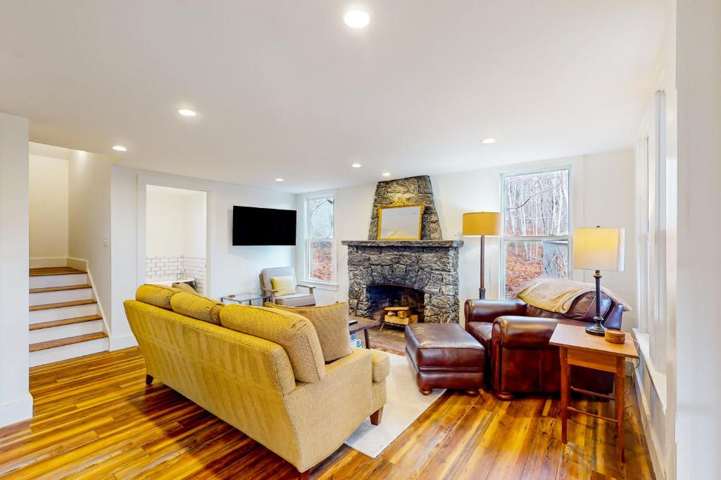 a living room with a couch and a fireplace at Bay Cottage in Boothbay Harbor