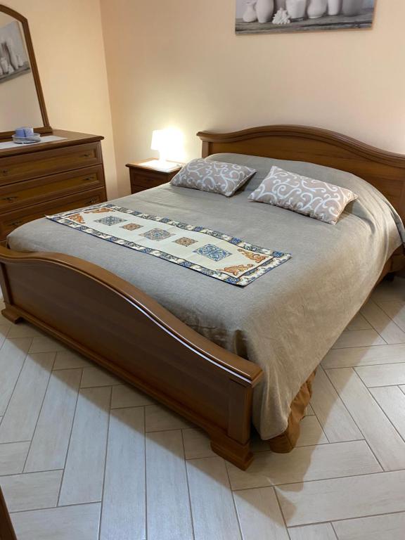a bed with a wooden frame and pillows on it at Casa Marconi in Aragona