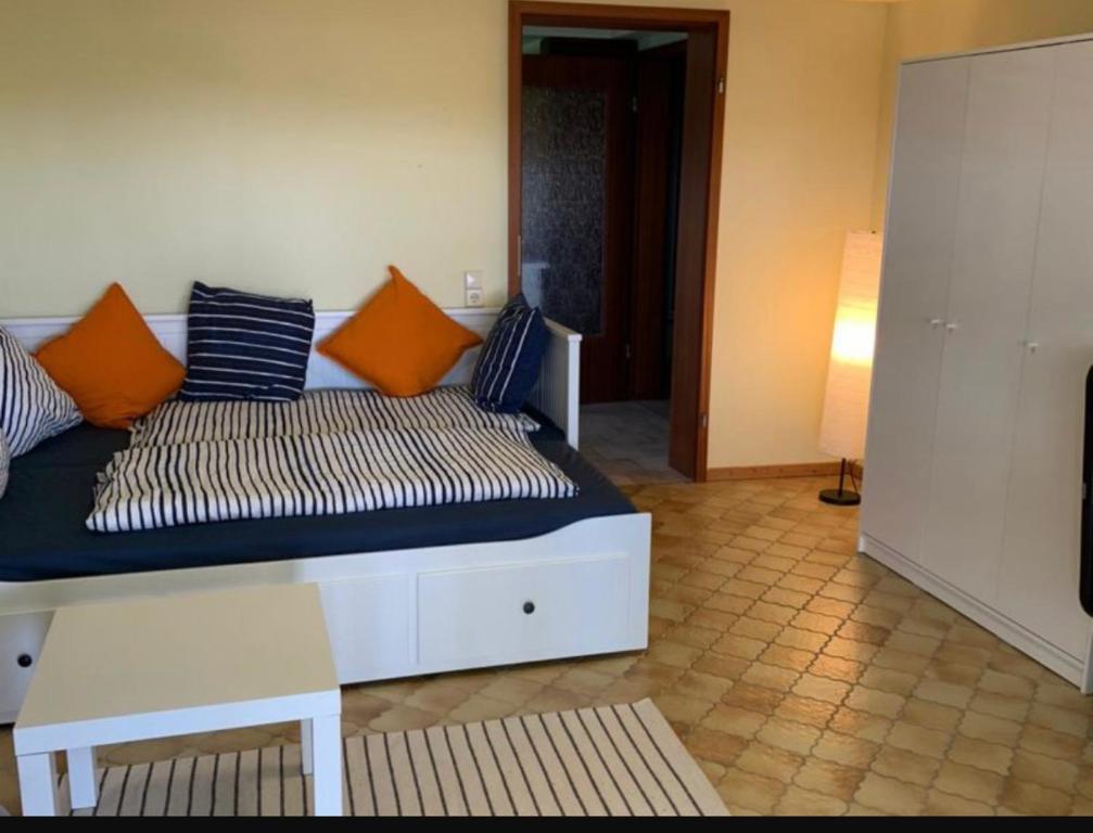 un sofá con almohadas de color naranja y azul en una habitación en Sonnenunterg, en Knüllwald