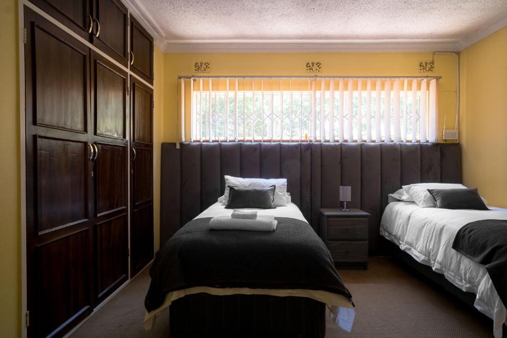 a bedroom with two beds and a window at Hillview Holiday Condo in Harare
