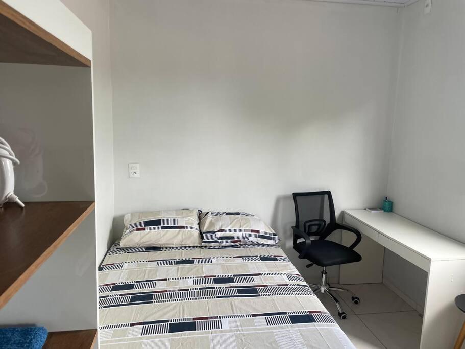 - une chambre avec un lit, un bureau et une chaise dans l'établissement Apto Serras Gerais, à Dianópolis