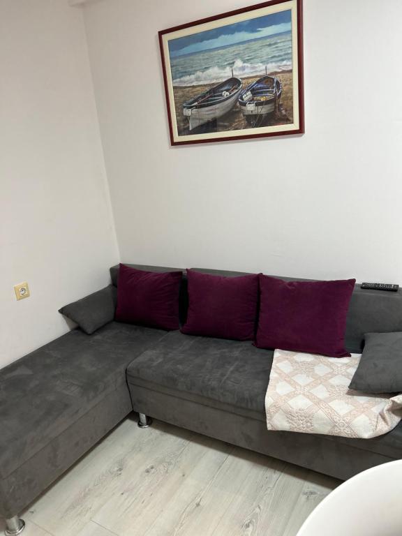 a couch in a living room with a picture on the wall at Apartments Oliva in Poreč