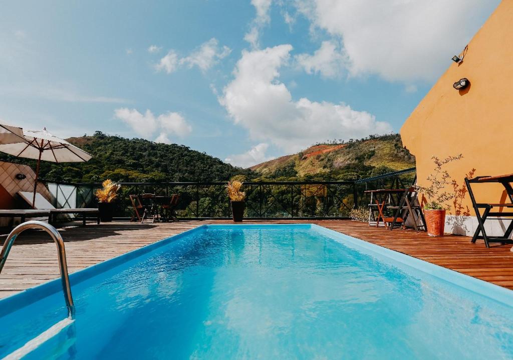 a swimming pool with a view of a mountain at Kastel Itaipava in Itaipava
