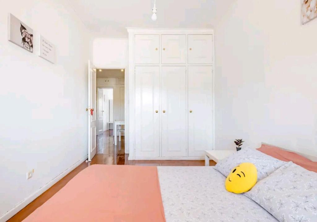 a bedroom with a bed with a yellow face pillow on it at Rigoli Room in Lisbon