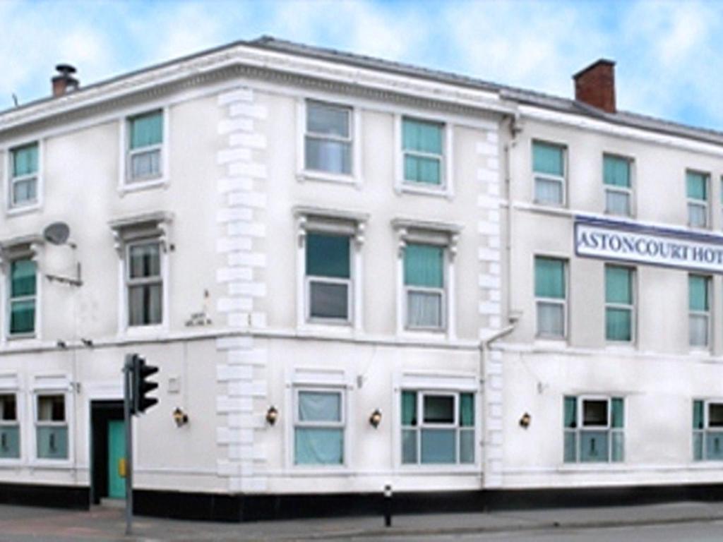 een wit gebouw op de hoek van een straat bij Aston Court Hotel in Derby