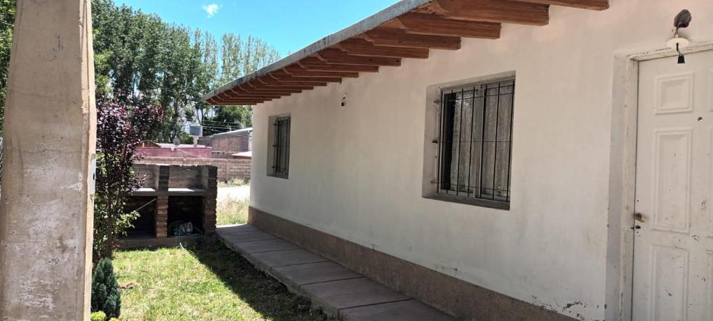 una casa bianca con una porta e una finestra di Departamento JERONIMO a Las Heras
