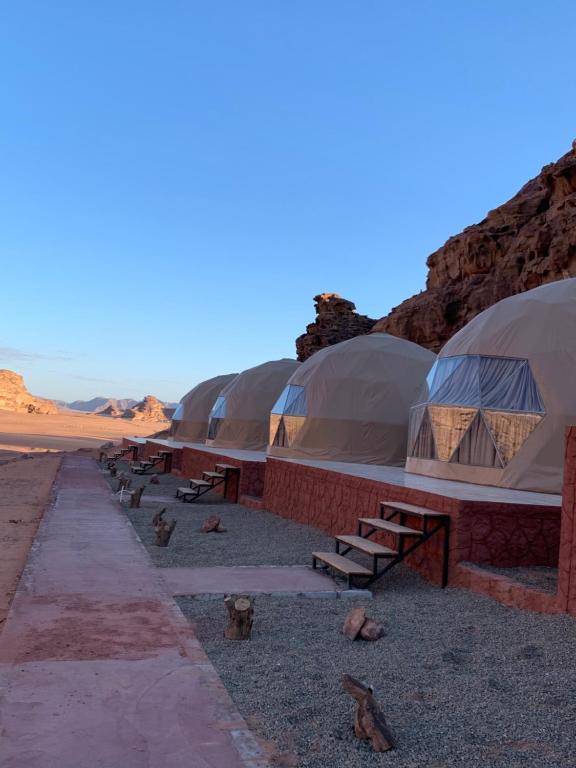 una fila de tiendas domeadas en el desierto en sand magic camp, en Wadi Rum