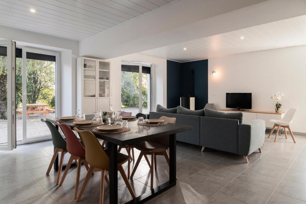 une salle à manger et un salon avec une table et des chaises dans l'établissement Gîte Sous le Verger, à Songeson