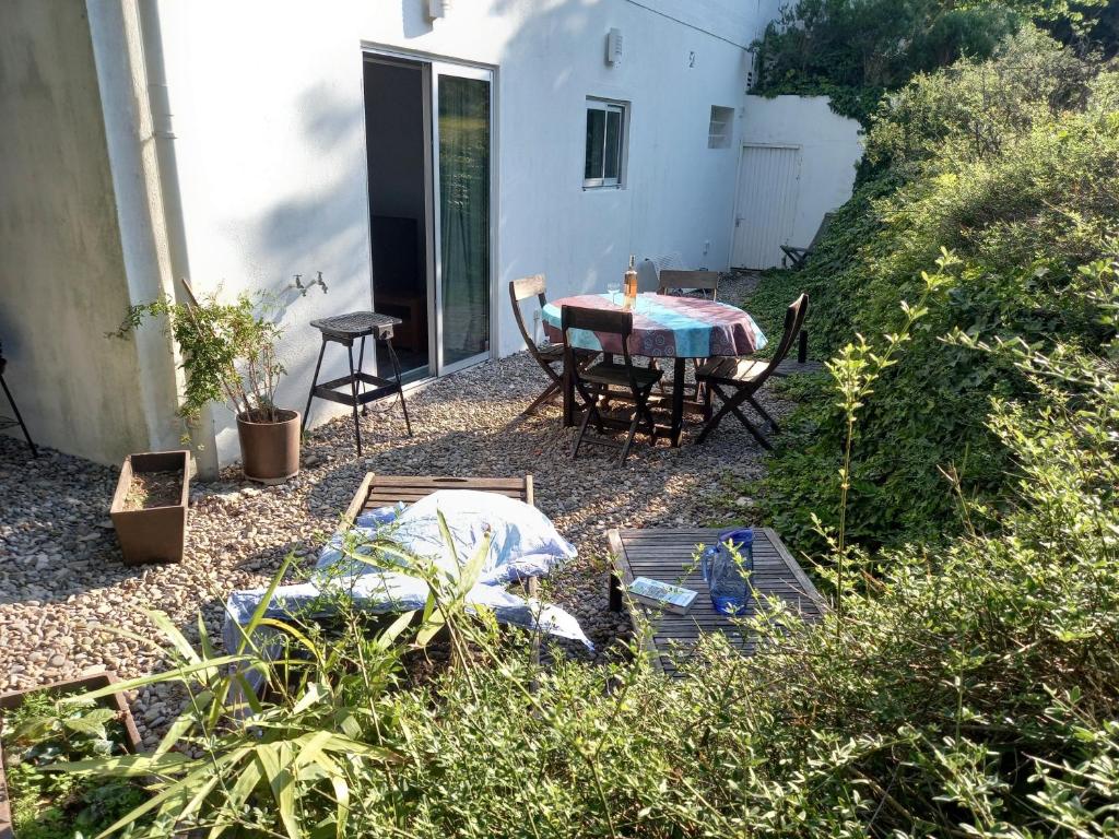 um pátio com uma mesa e cadeiras num quintal em T2 rez de jardin 5 min de Cassis em Carnoux