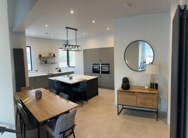a kitchen and dining room with a table and a mirror at Seabreeze Cottage in Portstewart