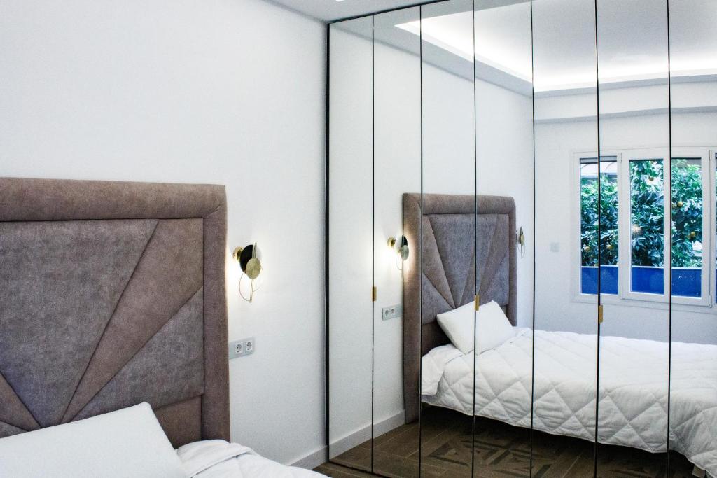 een spiegel in een slaapkamer met 2 bedden bij APARTAMENTO EN CALLE RECOGIDAS in Granada