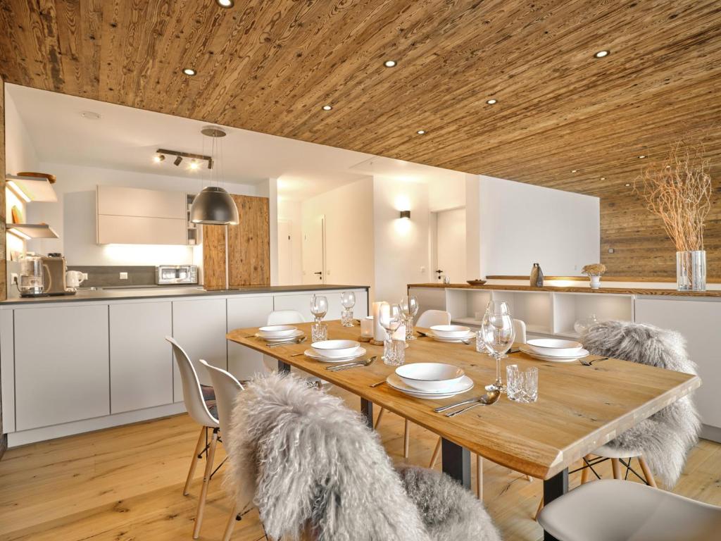 a kitchen and dining room with a wooden table and chairs at The Mountain Hideaway 211 by AA Holiday Homes SKI IN SKI Out Die Tauplitz in Tauplitz