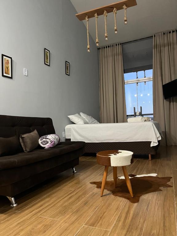ein Wohnzimmer mit einem Bett und einem Sofa in der Unterkunft Skyloft Chalé in Governador Valadares