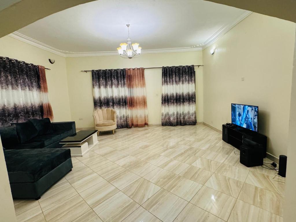 - un salon avec un canapé et une télévision dans l'établissement Binga villa, à Kisoro