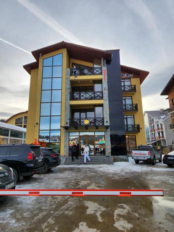 a yellow building with people standing outside of it at Snow King Hotel in Bakuriani